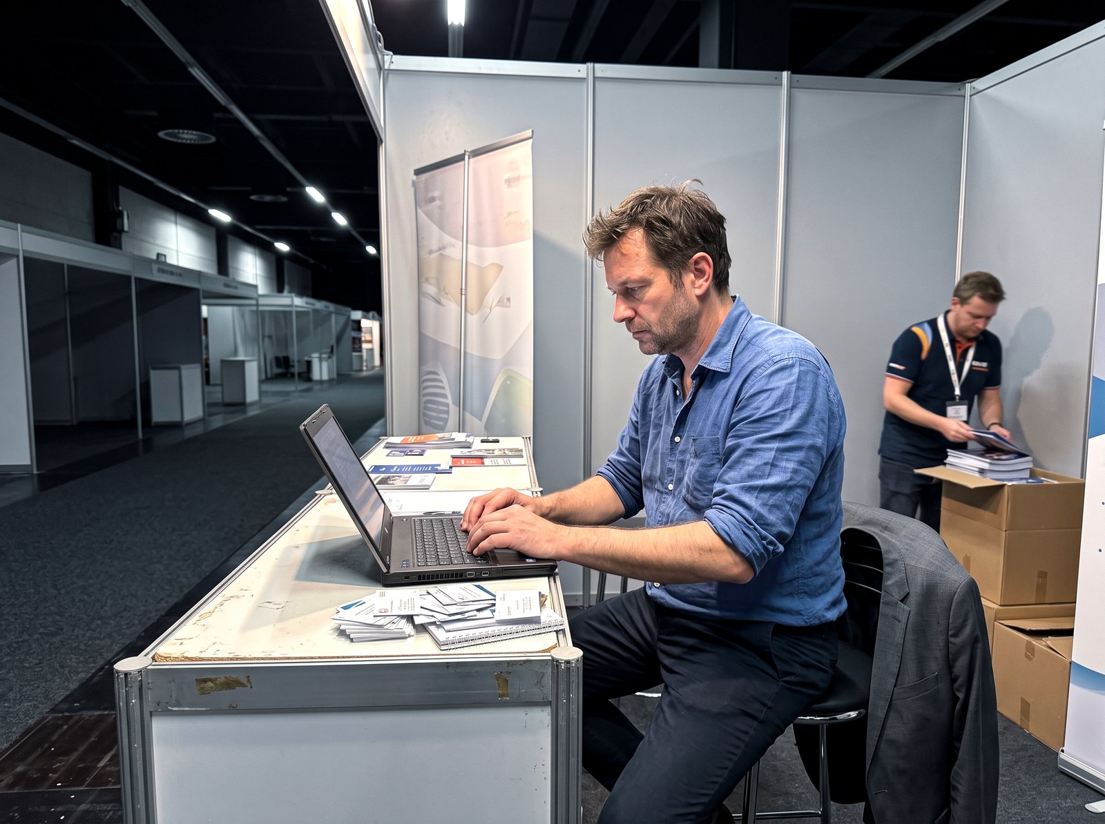 Symbolbild: Verkäufer erfasst abends am Messestand die Kontakte